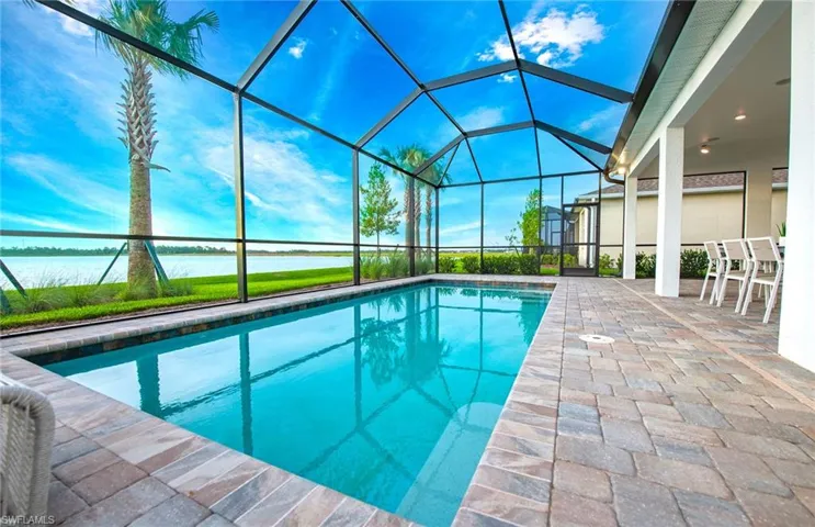View of swimming pool with a patio and glass enclosure