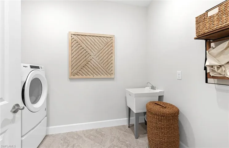 Clothes washing area with tile patterned floors and washer / clothes dryer