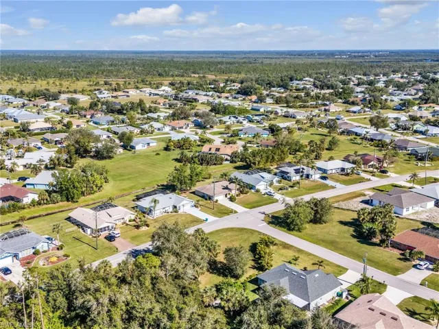 Aerial view of property and surrounding area with nearby suburban area