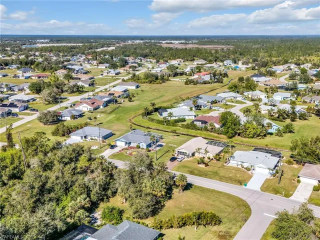 Aerial view of property and surrounding area featuring nearby suburban area
