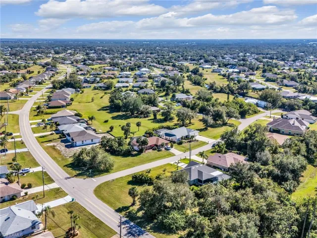 Aerial view of property and surrounding area featuring nearby suburban area