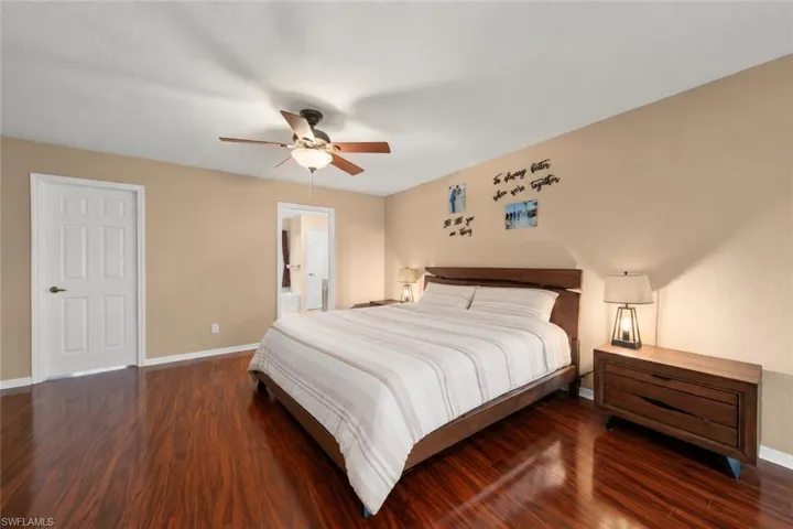 Spacious primary bedroom with wood-style flooring