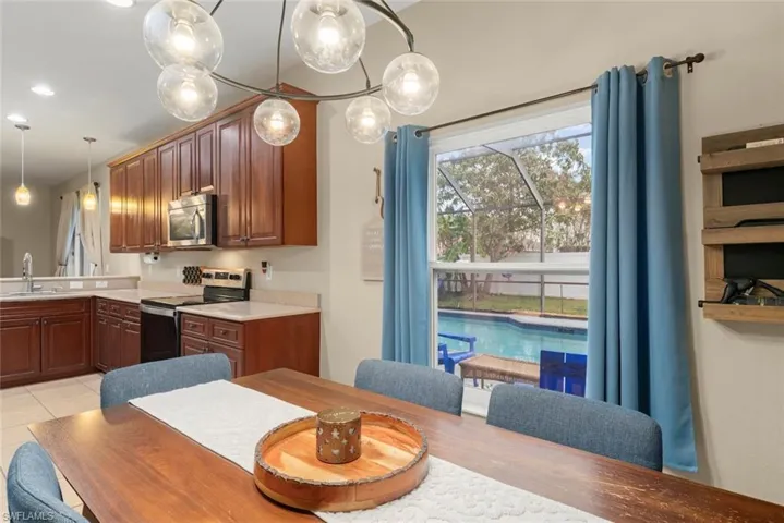 Dining area with a chandelier and window view of the pool