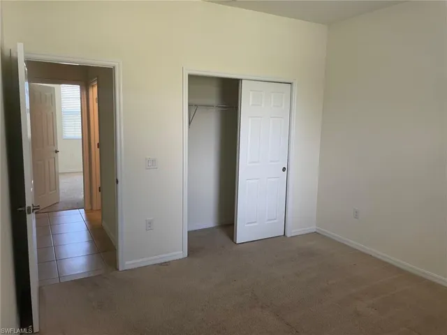 Unfurnished bedroom featuring light colored carpet and a closet