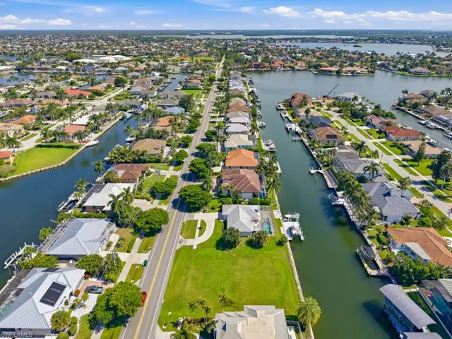 Aerial perspective featuring waterfront residential lots, direct canal access, deep-water frontage, and established tropical landscaping