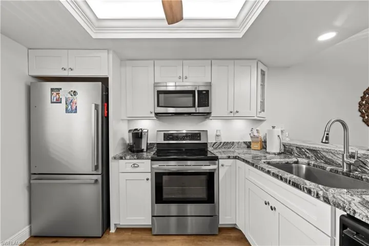 Kitchen featuring stainless steel appliances, a sink, light wood-style flooring, white cabinetry, and recessed lighting