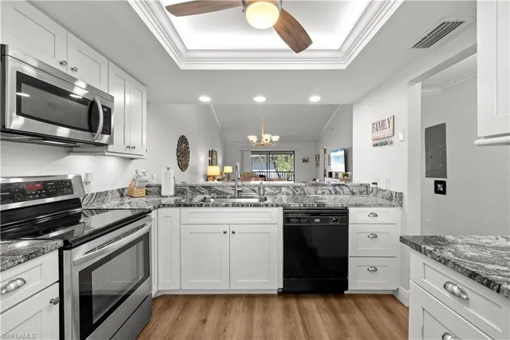 Kitchen featuring stainless steel appliances, a sink, light wood-style flooring, white cabinetry, and crown molding