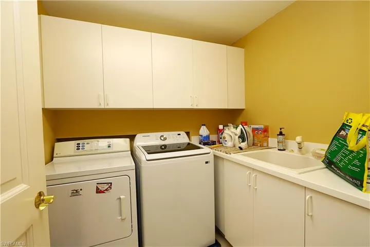 Laundry area featuring washing machine and dryer and cabinet space