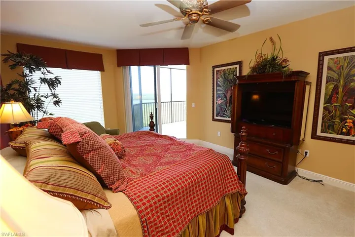 Bedroom with access to exterior, light colored carpet, and ceiling fan