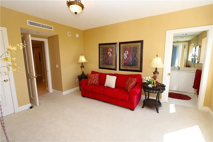 Living area featuring light carpet and baseboards