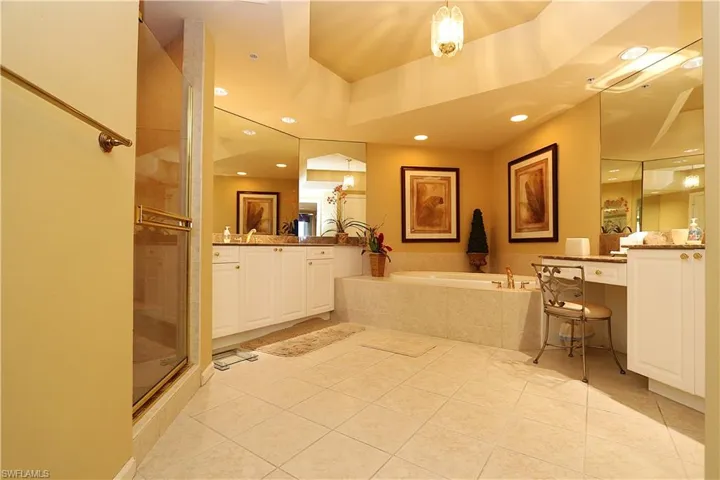 Bathroom with a bath, light tile patterned flooring, vanity, a shower stall, and recessed lighting