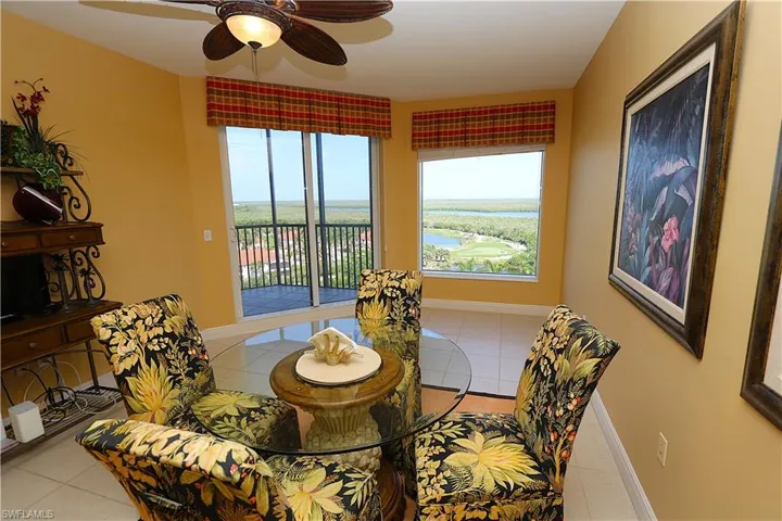 Dining space with light tile patterned floors, a water view, and ceiling fan