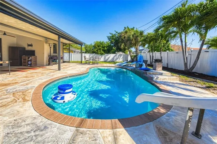Pool with slide and a large deck for lounging andELECTRIC ROLL DOWN SCREENS on LANAI