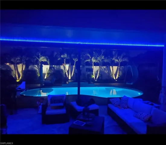 Outdoor pool with nighttime lighting with the electric screen rolled down
