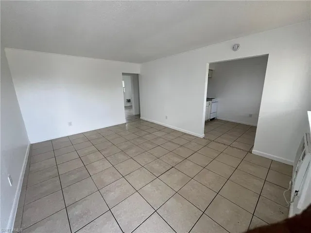 Unfurnished room featuring light tile patterned flooring and a textured ceiling