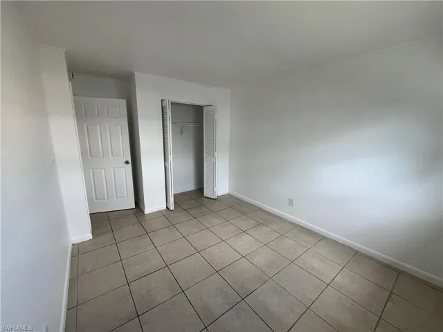 Unfurnished bedroom with light tile patterned floors and a closet
