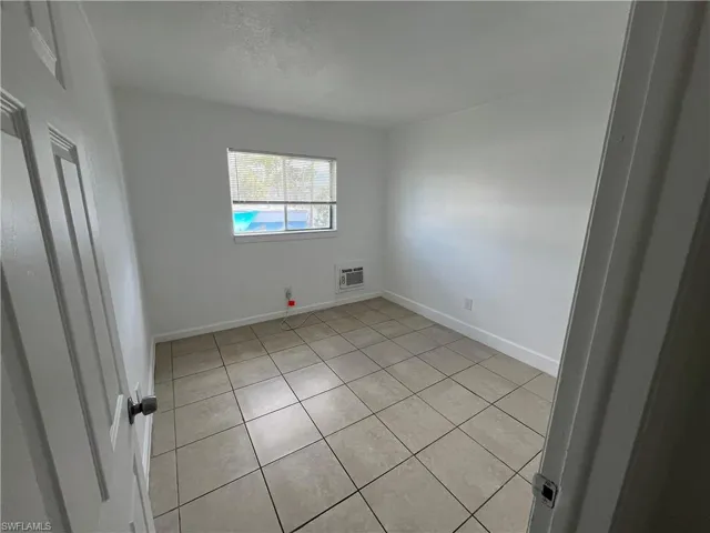 Empty room featuring light tile patterned flooring and a textured ceiling