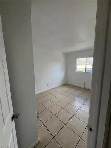 Empty room featuring light tile patterned floors and a textured ceiling
