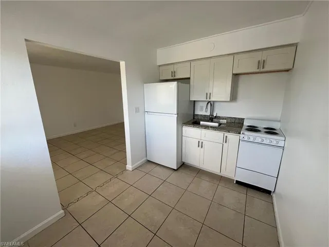 Kitchen with white appliances and light tile patterned floors