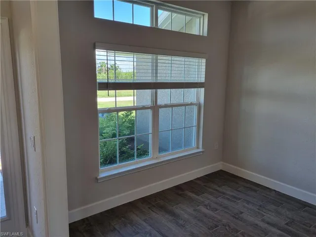 Spare room with dark hardwood / wood-style flooring