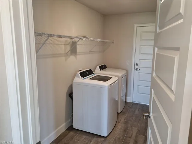 Laundry area featuring washer and clothes dryer and dark hardwood / wood-style floors