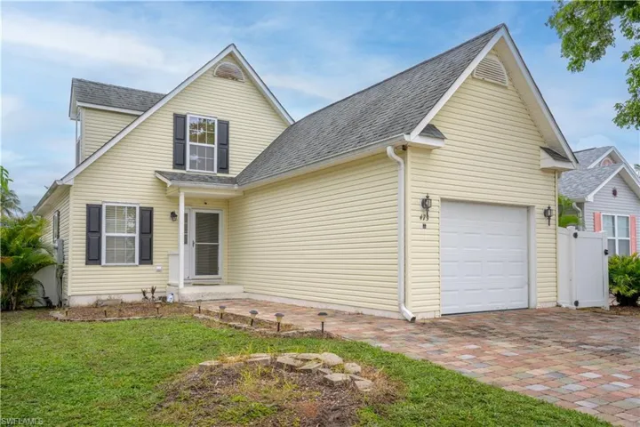 View of front property featuring a garage and a front yard
