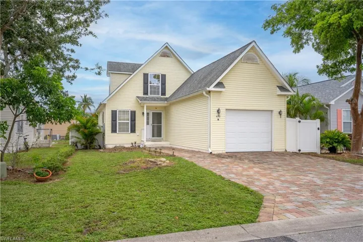 View of front facade featuring a garage and a front yard