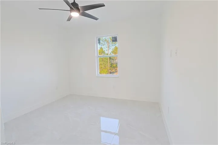 Empty room featuring baseboards and ceiling fan