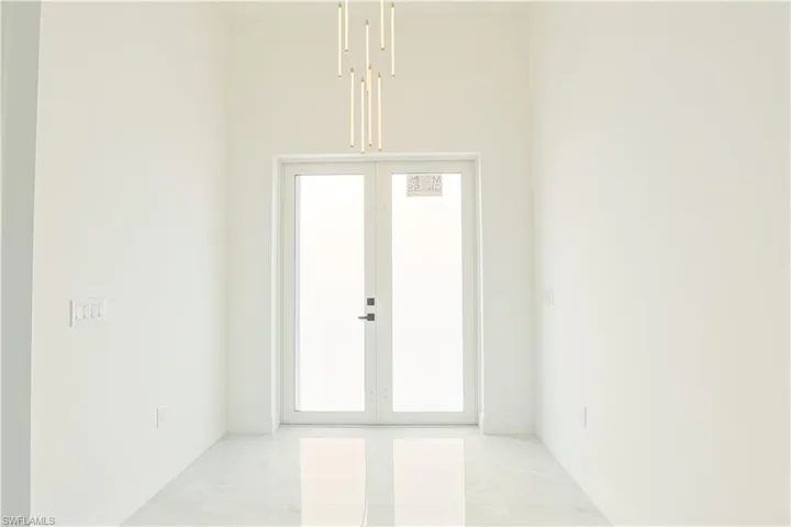 Entrance foyer featuring baseboards and marble finish floor
