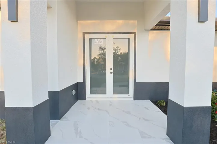 Property entrance featuring french doors and stucco siding