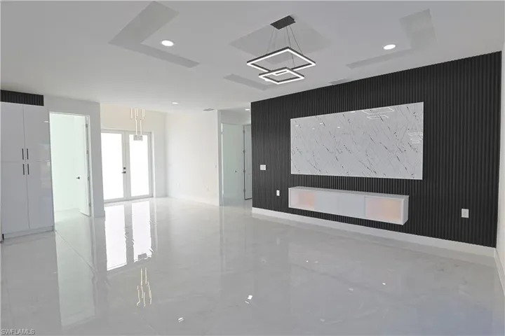 Spare room featuring recessed lighting, french doors, marble finish floor, and an accent wall