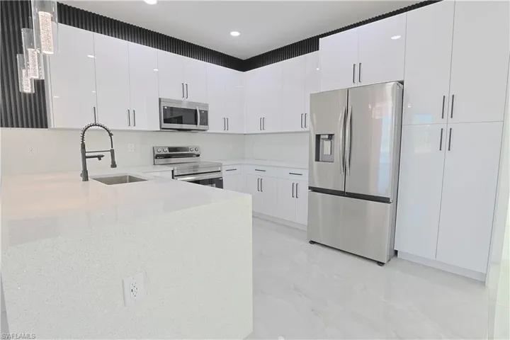 Kitchen with a sink, stainless steel appliances, and white cabinets