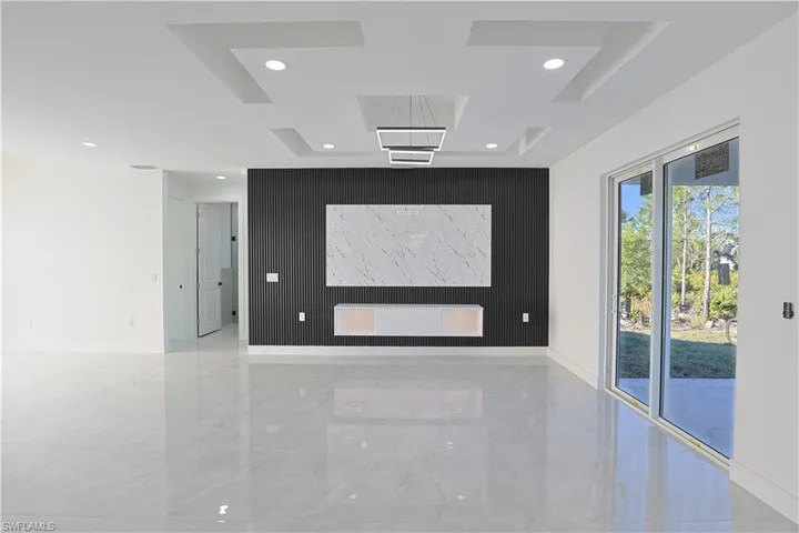 Spare room featuring an accent wall, recessed lighting, marble finish floor, and baseboards