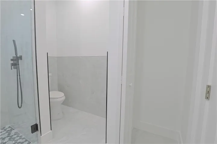 Full bathroom with toilet and a shower stall