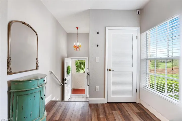 Foyer entrance featuring a chandelier, wood-style floors, and plenty of natural light