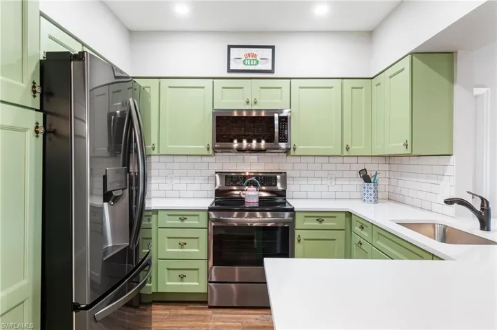 Remodeled kitchen with black stainless steel appliances and quartz countertops
