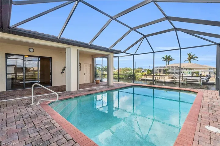 View of swimming pool with a canal view, and a lanai with screen enclosure