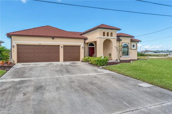 Mediterranean / spanish house with a front lawn and a garage