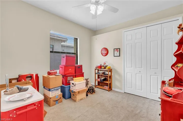Guest bedroom featuring light carpet and ceiling fan