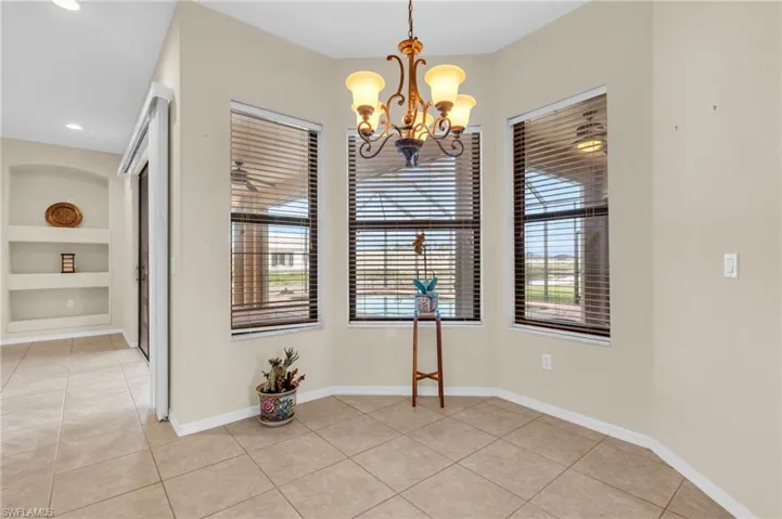 Dinette with light tile flooring, built in features, an inviting chandelier, and a wealth of natural light