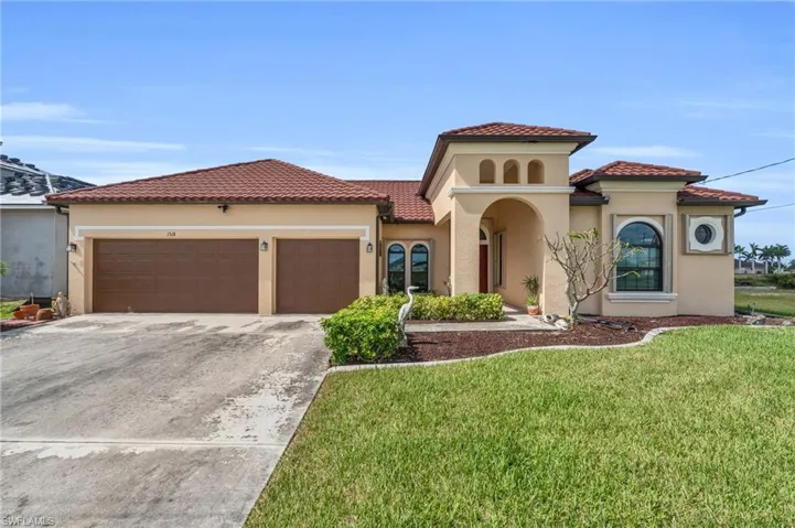 Mediterranean / spanish house featuring a garage and a front lawn