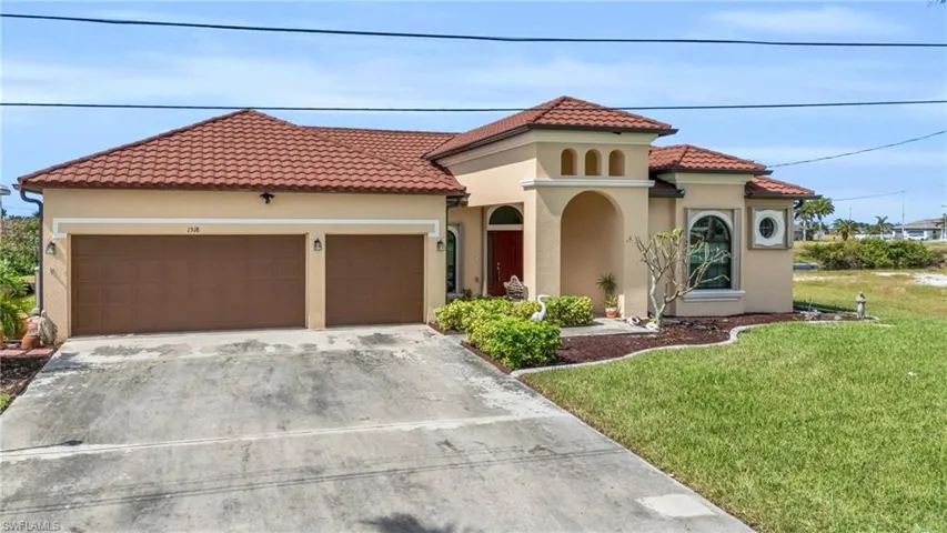 Mediterranean / spanish-style home featuring a garage and a front lawn