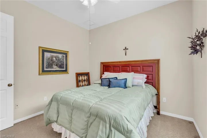 Carpeted bedroom featuring ceiling fan