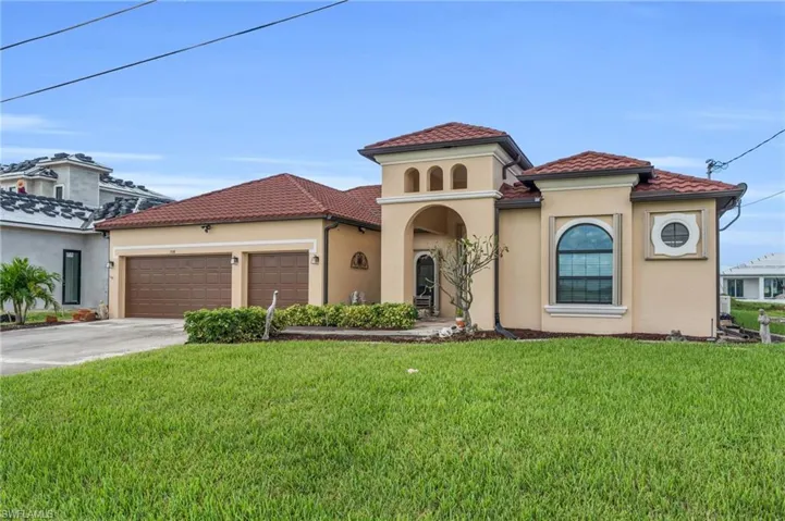 Mediterranean / spanish home with a garage and a front yard