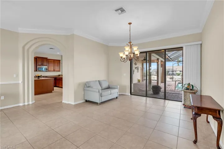 Sitting room featuring light tile patterned flooring, ornamental molding, and a notable chandelier