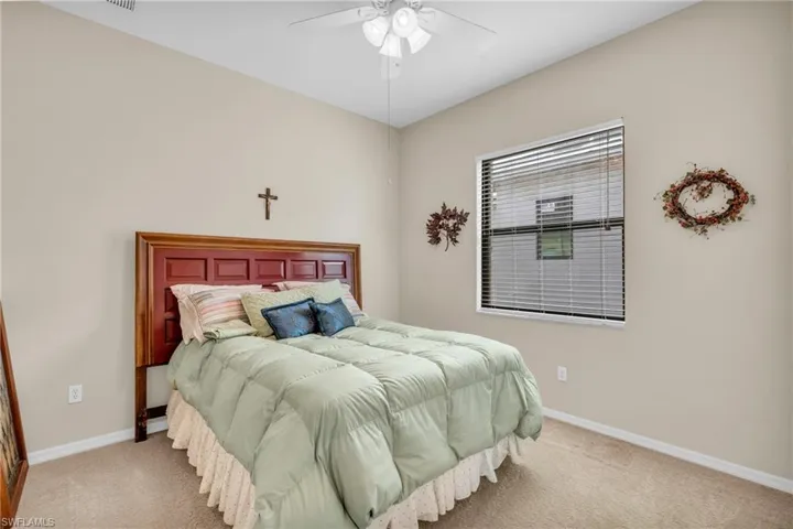 Carpeted bedroom featuring ceiling fan