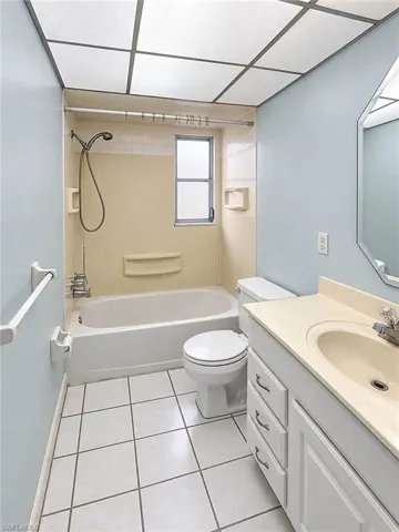 Bathroom with a white bathtub, toilet, and vanity with an integrated sink