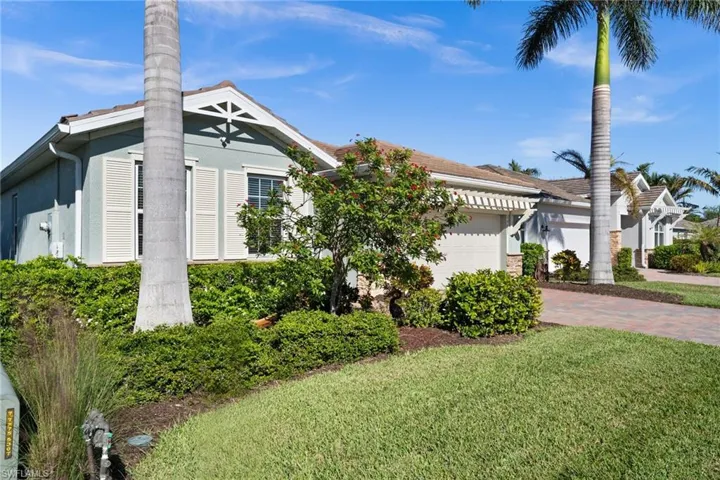 View of front facade featuring a front yard and a garage