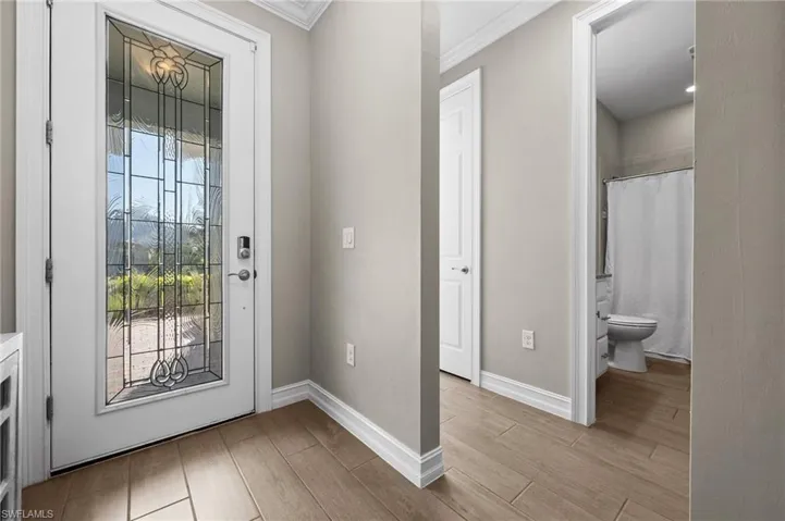 Foyer entrance featuring ornamental molding and light hardwood / wood-style flooring