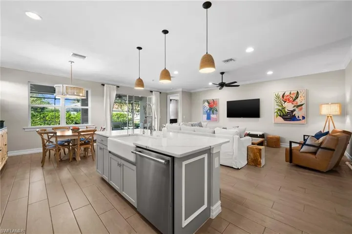 Kitchen with pendant lighting, dishwasher, a kitchen island with sink, sink, and ceiling fan